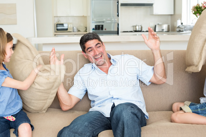 Family having pillow fight on sofa