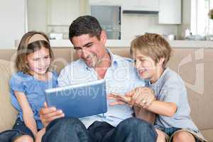 Father and children using digital tablet