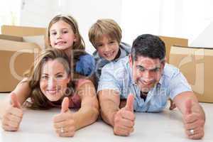 Family showing thumbs up in new house