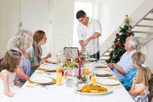 Father serving Christmas meal to family