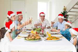 Family toasting wine while having Christmas meal