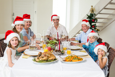 Happy family in Santa hats having Christmas meal