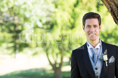 Handsome groom smiling at garden