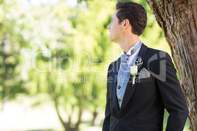 Groom looking away in garden