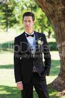 Confident bridegroom in tuxedo at garden