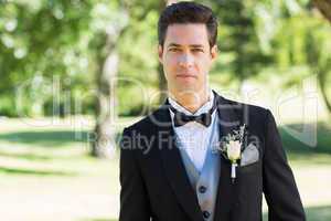 Confident groom in tuxedo at garden