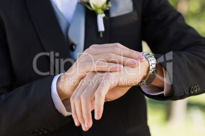 Midsection of groom checking time