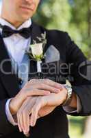 Midsection of bridegroom checking time