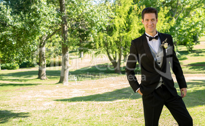 Handsome bridegroom standing in garden