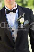 Midsection of groom wearing boutonniere