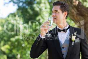 Thoughtful groom drinking champagne