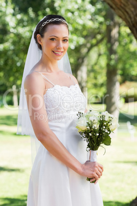 Bride holding flowers in garden