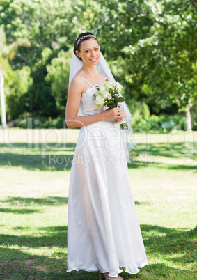 Portrait of bride holding flower bouquet in garden