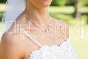 Closeup of bride wearing necklace in garden