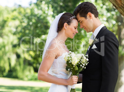 Newly wed couple with head to head in garden