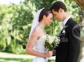 Newly wed couple with head to head in garden