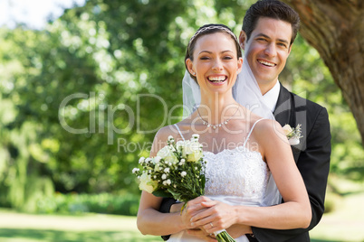 Newly wed couple with flower bouquet in park