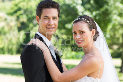 Bride and groom smiling in garden