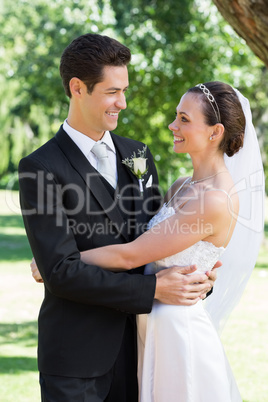 Newly wed couple embracing each other in garden