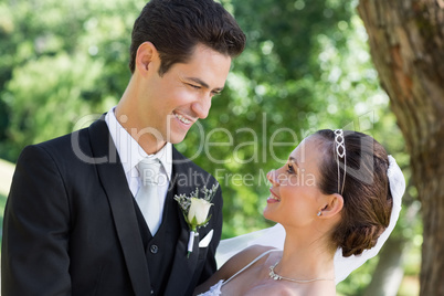 Bride and groom looking at each other in garden