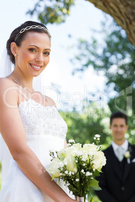 Bride holding flower bouquet in garden