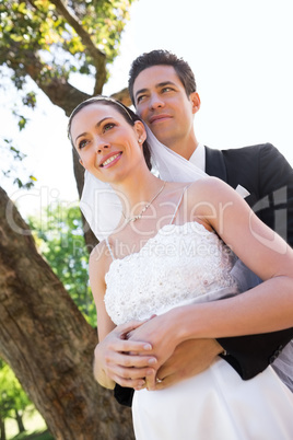 Thoughtful newly wed couple standing in garden