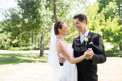 Loving bride and groom dancing in garden