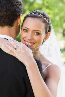 Happy bride embracing groom in garden