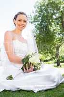 Confident bride holding bouquet in garden