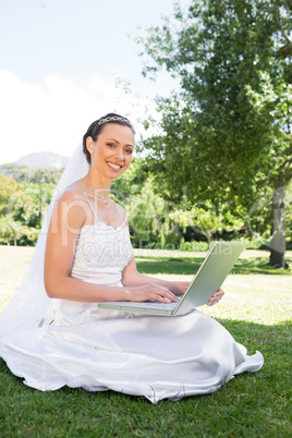 Bride using laptop in garden