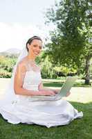 Bride using laptop in garden