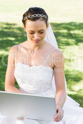 Bride using laptop in garden