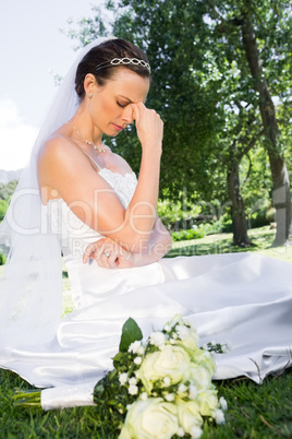 Depressed bride sitting in garden