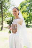 Bride showing wedding ring in garden