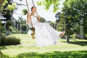 Young bride swinging in garden