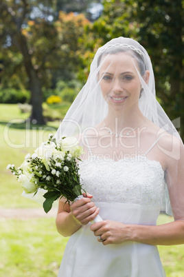 Beautiful bride with flower bouquet wearing veil