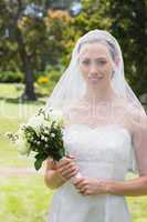 Beautiful bride with flower bouquet wearing veil