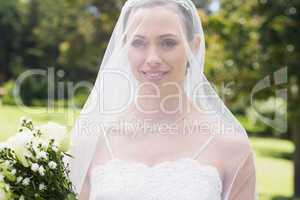 Closeup of bride wearing veil in garden