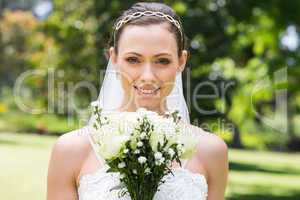 Bride with flower bouquet smiling in garden