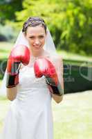 Bride wearing boxing gloves in garden