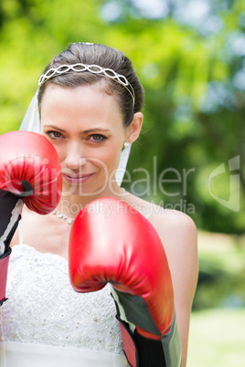 Woman in wedding dress wearing boxing gloves