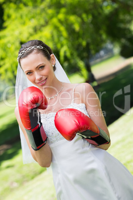 Bride with red boxing gloves in park