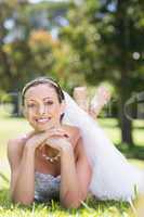 Beautiful bride lying on grass in park
