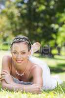 Beautiful young bride relaxing on grass
