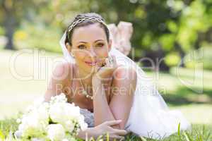 Young bride lying on grass in park