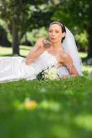 Bride blowing a kiss in park