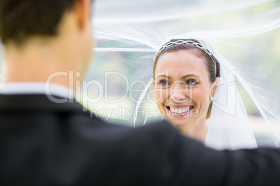 Groom lifting bridal veil