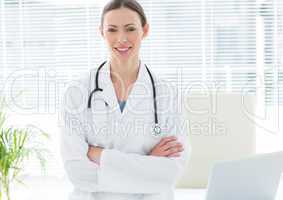 Happy female doctor with arms crossed