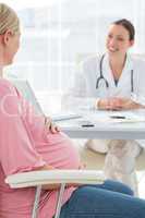 Pregnant woman consulting female doctor