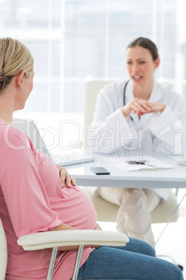 Pregnant woman discussing with doctor